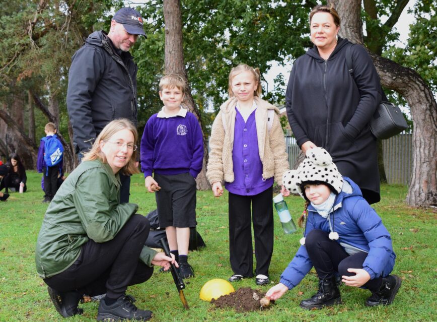 A group of parents and their children help plant our bulbs